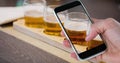 Hand photographing beer glasses through smart phone at bar Royalty Free Stock Photo