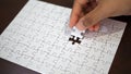 Hand pick a piece of jigsaw to connect success on wooden table top selected focus