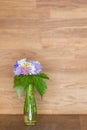 Hand picked flowers in vase on wooden background