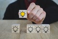 Hand picked a wooden cubes with the yellow light bulb symbol on wooden table. New idea, Innovation and Solution concepts Royalty Free Stock Photo