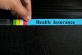 Hand picking health insurance file record in black binder folder. Health insurance benefit concept.