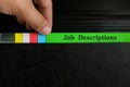 Hand picking job description file in black binder folder. Human resources concept. Royalty Free Stock Photo
