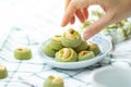 Hand picking Matcha Green Tea Cookies Singapore or Matcha Green Tea cashew Cookies with dried flower blurred on green vintage Royalty Free Stock Photo