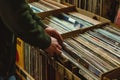 Hand picking old vinyl records from a shelf in a book store.