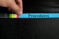 Hand picking procedures file record in black binder folder. Work procedure concept.