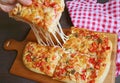 Hand Picking a Slice of Pizza Alla Pala with Mouthwatering Stretching Cheese