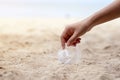A hand picking up a plastic glass trash on the beach Royalty Free Stock Photo