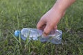 Hand picks up a plastic bottle from the grass Royalty Free Stock Photo