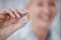 Hand, pill and healthcare with a medicine professional holding a vitamin or supplement closeup in a pharmacy. Tablet