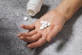 Hand with pills on the table. Concept on the topic of pills poisoning