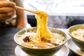 Hand pinching noodle with steam in Ramen Broth with Spicy Bean Paste Miso Ramen.