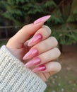 a hand with pink manicured nails