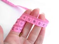 Hand with pink tape measure against white background Royalty Free Stock Photo