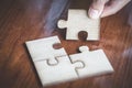 Hand placed the last piece of jigsaw puzzle, conceptual of problem solving, finding a solution