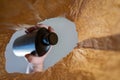 A hand places a black plastic bottle from a paper bag. A mature man`s hand holds a bottle of shampoo or shower gel over the open Royalty Free Stock Photo