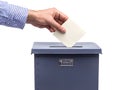 Hand placing a ballot in a blue ballot box, representing the voting process and democracy Royalty Free Stock Photo