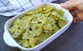 Hand Placing a Bowl of Homemade Farfalle Pasta with Pesto Sauce on Wooden Table Royalty Free Stock Photo