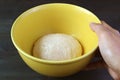 Hand placing a bowl of kneaded dough on the table to let it rises before baking Royalty Free Stock Photo