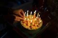 Hand placing candles on a birthday cake