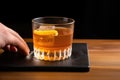 hand placing a coaster under a glass of whiskey sour