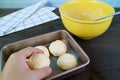 Hand placing dough in the baking tray for baking Brazilian cheese bread