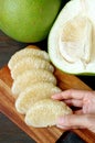 Hand Placing Pomelo Fruit Segments after Peeled on a Cutting Board Royalty Free Stock Photo
