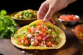 hand placing fresh salsa on homemade chalupa Royalty Free Stock Photo