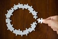 Hand placing the last jigsaw puzzle piece,conceptual of problem solving