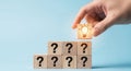 Hand placing lightbulb block on question mark blocks Royalty Free Stock Photo