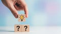 Hand Placing Lightbulb Idea Block on Question Marks for Creative Solutions Royalty Free Stock Photo