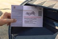 Hand placing mail in ballot into a mail box