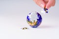 Hand Placing Puzzle Piece on Globe with Missing Section Royalty Free Stock Photo