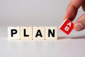 Hand Placing Red \'A B\' Cube Next to \'PLAN\' Blocks, Symbolizing Multiple Strategic Options Royalty Free Stock Photo