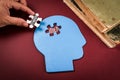 Hand placing Success puzzle piece into blue human head shape with word Idea inside Royalty Free Stock Photo