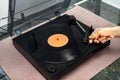 Hand placing the turntable needle on the vinyl spinning