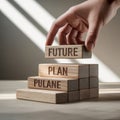 A hand placing a wooden block with the word future on of a stack of blocks with plan and pulane Royalty Free Stock Photo