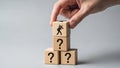 Hand Placing Question Mark and Worker Symbol Wooden Blocks in Stack Royalty Free Stock Photo