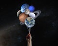 Hand with planets shaped balloons in solar system. Elements of this image furnished by NASA Royalty Free Stock Photo