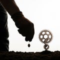 The hand plants the gear like a seed in the ground. Royalty Free Stock Photo