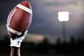 Composite image of hand of a player holding american football Royalty Free Stock Photo