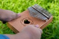 Hand playing kalimba or mbira is an African musical instrument.made from wooden board with metalInstrument in garden