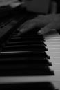 Hand playing piano perspective in black and white