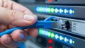 Hand plug blue ethernet cable into network server for data connection Royalty Free Stock Photo