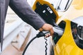 Hand Plugging In Electric Car Outside Office In Car Park Charging