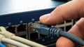 Hand Plugging Ethernet Cable into Network Switch Port Royalty Free Stock Photo