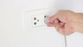 Hand Plugging In A Power Cord And Then Unplugging It In A Typical Electrical Outlet.