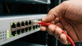 Hand Plugging Red Ethernet Cable into Network Switch Port Royalty Free Stock Photo