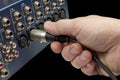 Hand plugging an xlr audio cable into a mixing console Royalty Free Stock Photo