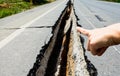 Hand point to cracked road, cracked road aftetr earthquake Royalty Free Stock Photo