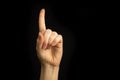 Hand point up. Woman hand gesture, pointing sign, gesture look at this, pay attention. Black background photo